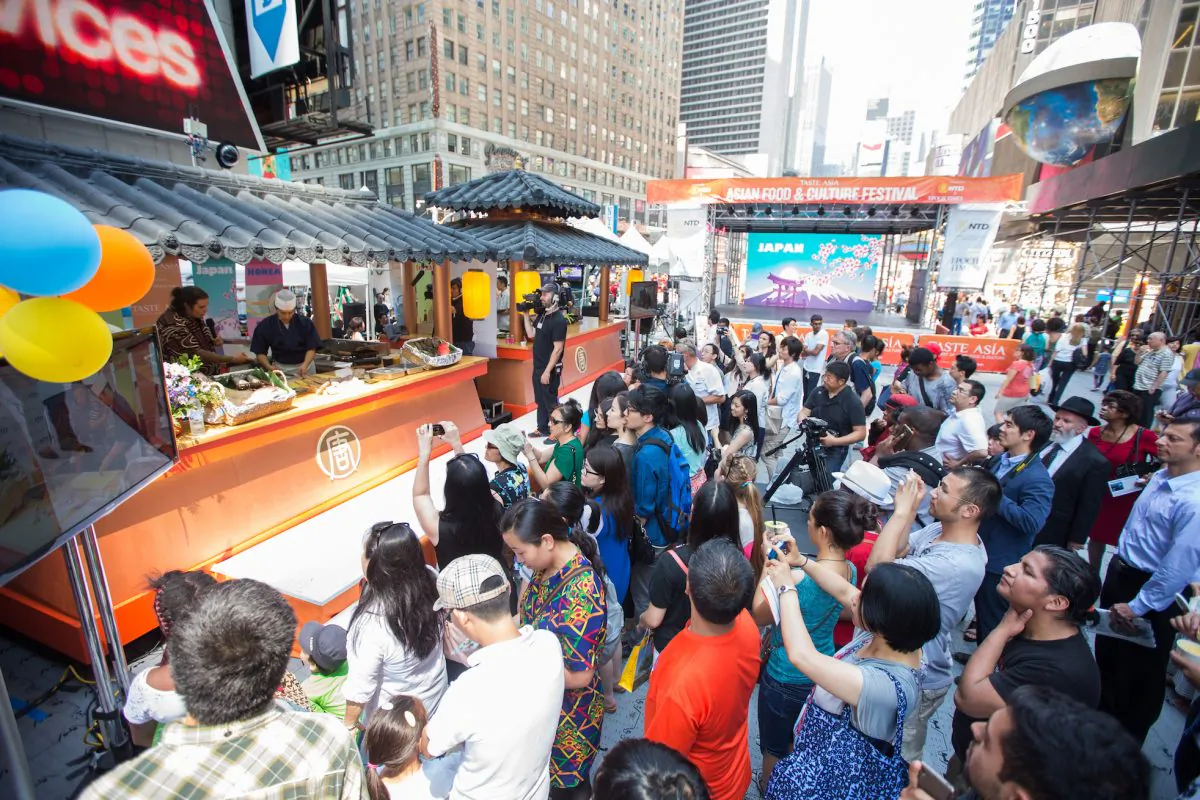 Onlookers gather on Times Square for the Taste Asia’s inaugural food and culture festival featuring top chefs from around the world, in Manhattan on June 25, 2014. The Chinese culinary competition begins on June 26 focusing on ethnic Chinese cuisine. Taste Asia is presented by NTD Television and Epoch Times. (Edward Dai/Epoch Times)