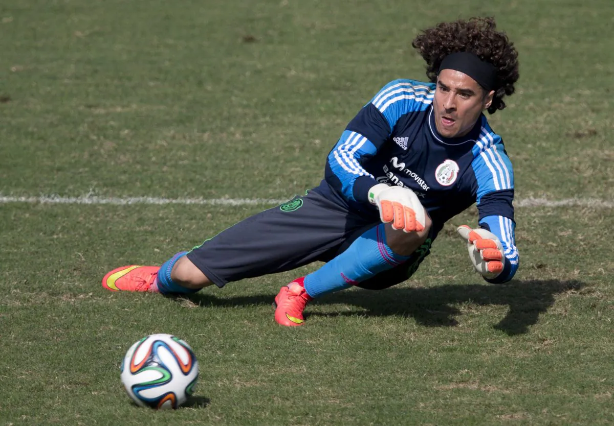 Mexico goalkeeper Guillermo Ochoa leaps to trap a ball during a training session in Santos, Brazil, Thursday, June 26, 2014. Mexico will face the Netherlands in their next World Cup match in Fortaleza, Sunday. (AP Photo/Eduardo Verdugo)