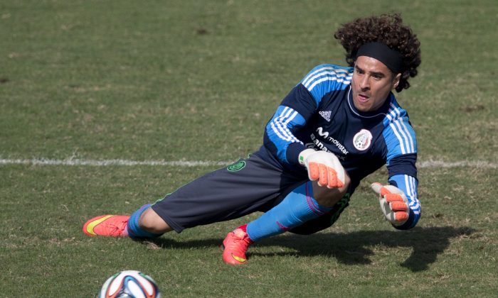 Mexico goalkeeper Guillermo Ochoa leaps to trap a ball during a training session in Santos, Brazil, Thursday, June 26, 2014. Mexico will face the Netherlands in their next World Cup match in Fortaleza, Sunday. (AP Photo/Eduardo Verdugo)