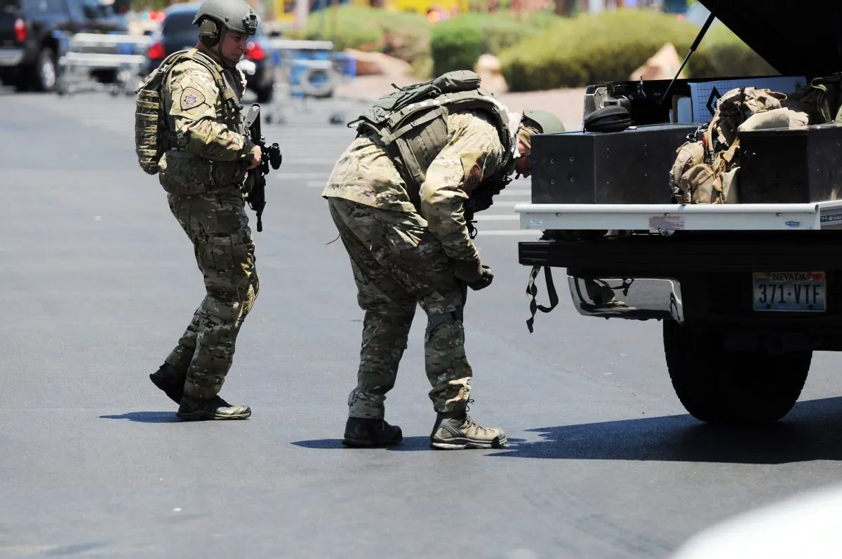 Las Vegas police officers prepare to go near the scene of a shooting in Las Vegas, Sunday, June 8, 2014. The spree began around 11:30 a.m. Sunday when a man and woman walked into CiCi's Pizza and shot two officers who were eating lunch, Las Vegas police spokesman Larry Hadfield said. (AP Photo/Las Vegas Review-Journal, Eric Verduzco)