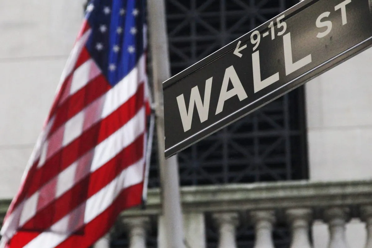 The American flag and Wall St. street sign outside the New York Stock Exchange, in New York, on June 27, 2014. (Mark Lennihan/AP Photo)