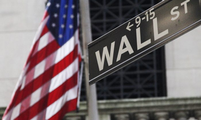 The American flag and Wall St. street sign outside the New York Stock Exchange, in New York, on June 27, 2014. (Mark Lennihan/AP Photo)