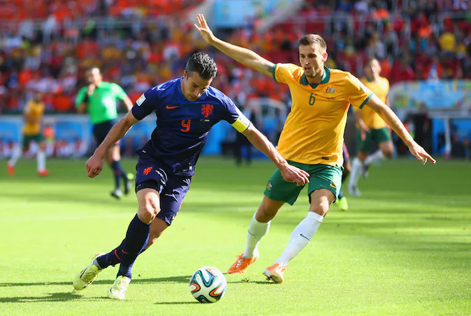 Robin van Persie of the Netherlands controls the ball as Matthew Spiranovic of Australia gives chase during the 2014 FIFA World Cup Brazil Group B match between Australia and Netherlands at Estadio Beira-Rio on June 18, 2014 in Porto Alegre, Brazil. (Photo by Jeff Gross/Getty Images)