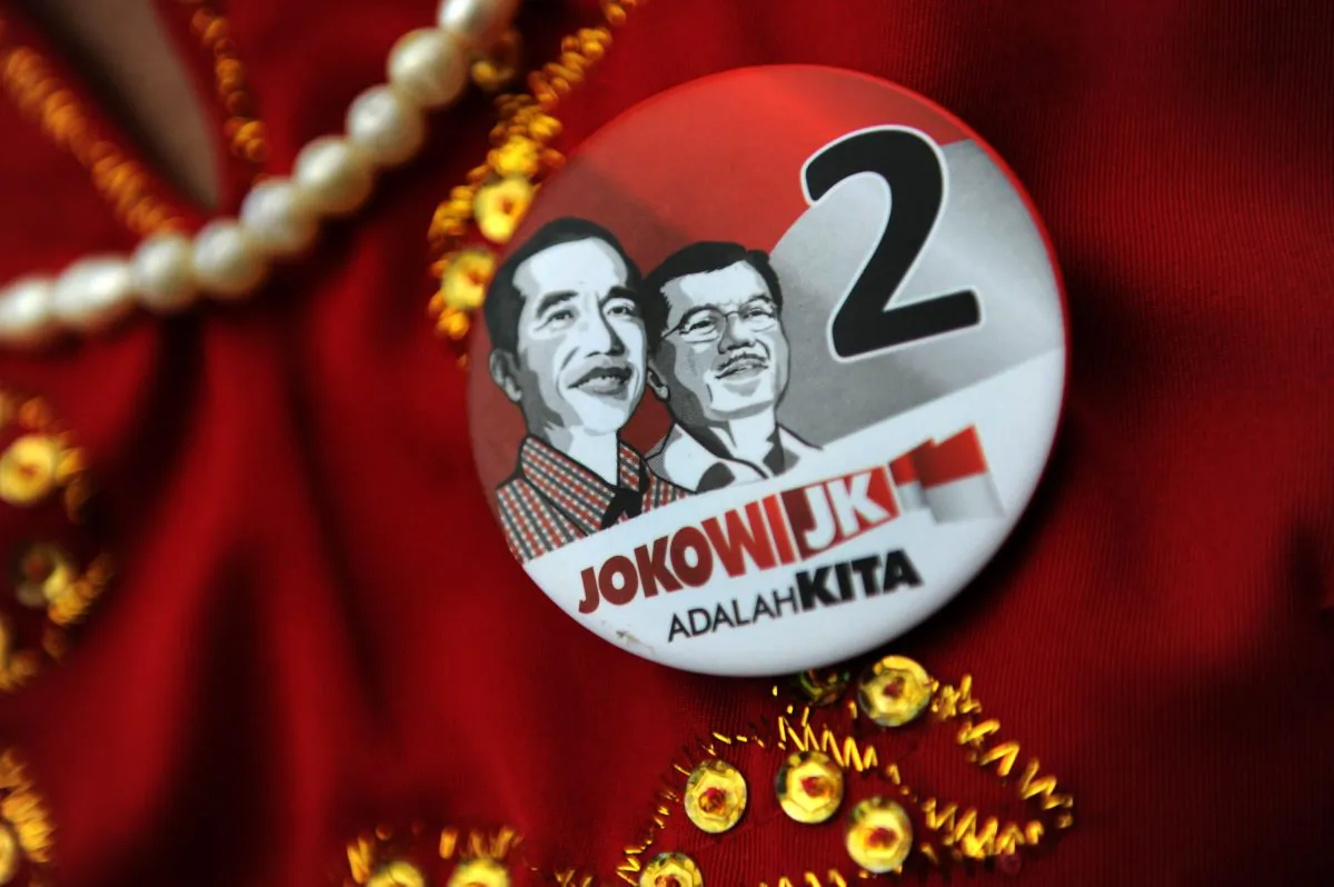 A supporter of Indonesian frontrunner presidential candidate Joko Widodo (L-portrait), representing a region and wearing pin bearing his portrait and running mate Jusuf Kalla (R-portrait), attends a campaign rally in Jakarta on June 25, 2014. The popularity gap between Widodo and opponent Prabowo Subianto, a former general narrowed as the campaign race for the July 9 presidential election heats up. (Romeo Gacad/AFP/Getty Images)