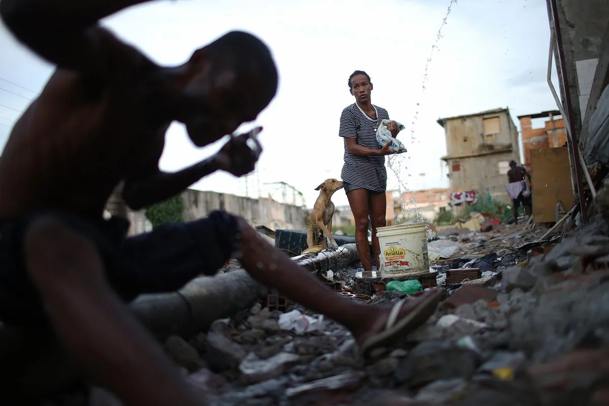 A woman washes clothes from a small hose amongst the remains of homes demolished to make way for World Cup construction that never happened near the Maracana stadium in Rio de Janeiro, Brazil, on May 22, 2014. The World Cup  has fallen short of its lofty environmental goals, but its legacy could be a shift in how global sporting events address social injustice. (Mario Tama/Getty Images)