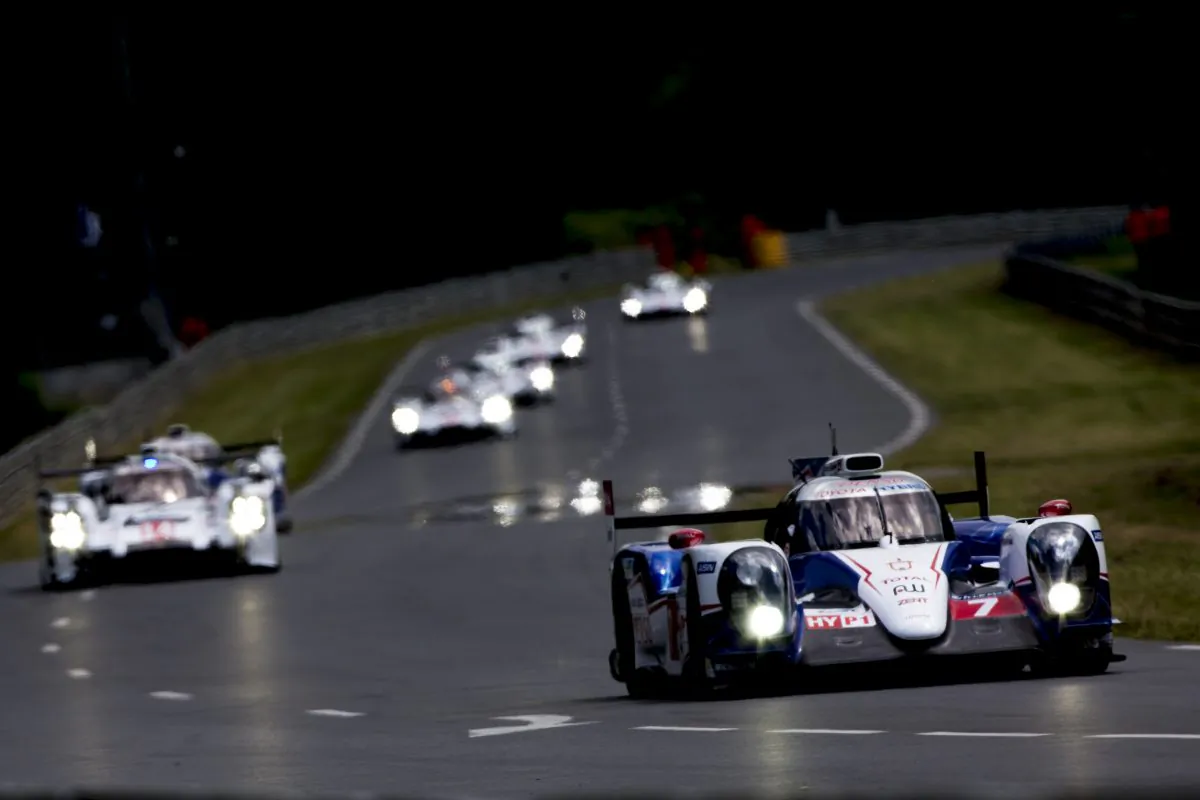 The #7 Toyota TS 040 Hybrid leads the #20 Porsche 919 Hybrid and the rest of the field during the Le Mans 24h Race on June 14, 2014 in Le Mans, France. (Andrew Hone/Getty Images)