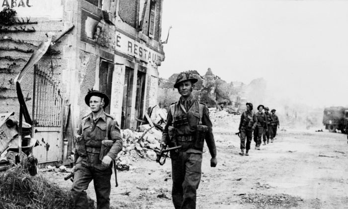 Allied soldiers cross 08 June 1944 the village of Douet, after the town of Bayeux fell, two days after the allied troops landed on Normandy beaches (north-west of France), to come as reinforcements during the historic D-Day, 06 June 1944, during WWII. (STF/AFP/Getty Images)