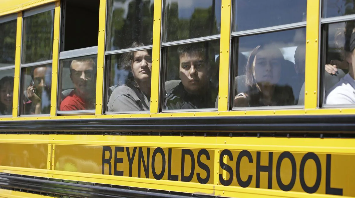 In this file photo, Students look for family members after arriving at a shopping center parking lot in Wood Village, Ore., after a shooting at Reynolds High School Tuesday, June 10, 2014, in nearby Troutdale. A gunman killed a student at the high school east of Portland Tuesday and the shooter is also dead, police said. (AP Photo/Rick Bowmer)