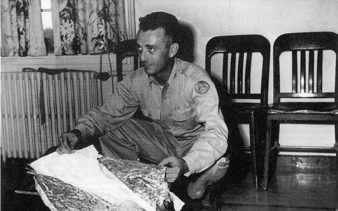 Major Jesse Marcel holds up pieces of a crashed weather balloon found 75 miles northwest of Roswell, N.M., in June 1947. Purported leaked documents, known as the Majestic 12 documents, claim that the weather balloon was a cover story for an extraterrestrial crash. If the documents are genuine, then a highly secret agency known as the Majestic 12 may have overseen the cleanup and cover-up of said crash. (United States Air Force/AFP/Getty Images)

