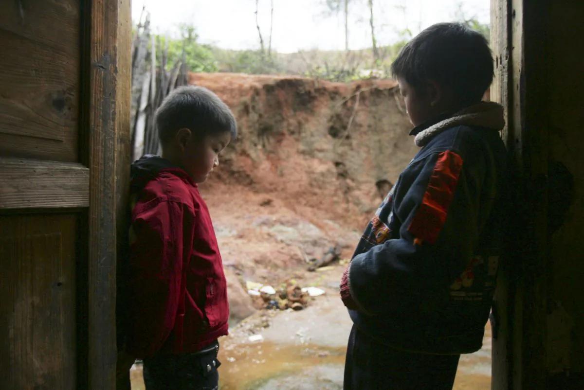 Two children confirmed to be suffering from lead poisoning, stand in their home March 16, 2007 in Chaxian County of Hunan Province, China. About 100 people from four villages, most of them children, were confirmed to be suffering from lead poisoning resulting from a nearby smelting plant that was closed down after running for 12 years. Most recently, over 300 children in Dapu Town, Hengdong County of Hunan Province show high levels of lead in their blood. The town’s mayor says they’ve been chewing on their pencils, it’s not from the chemical factory in town. (China Photos/Getty Images) 