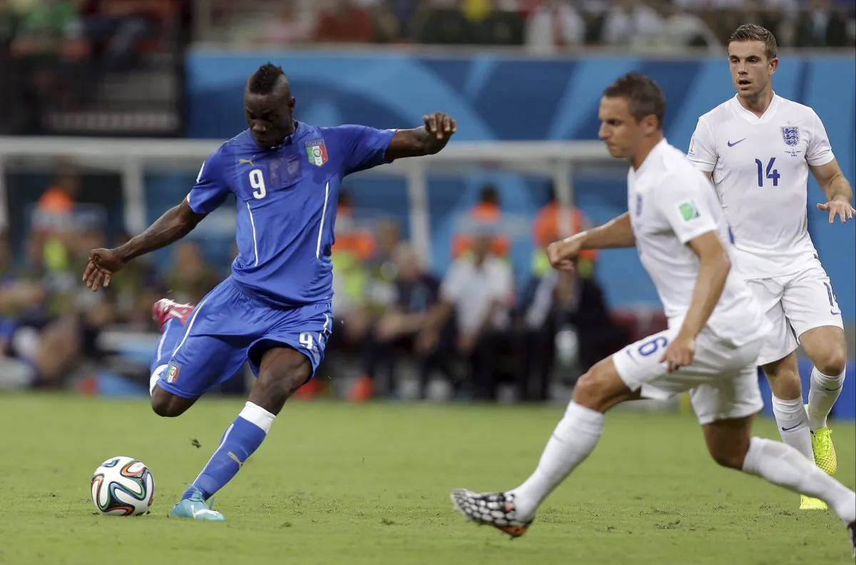 Italy's Mario Balotelli, left, gets in a shot as England's Phil Jagielka, center, and Jordan Henderson, right, defend during the group D World Cup soccer match between England and Italy at the Arena da Amazonia in Manaus, Brazil, Saturday, June 14, 2014. (AP Photo/Martin Mejia)