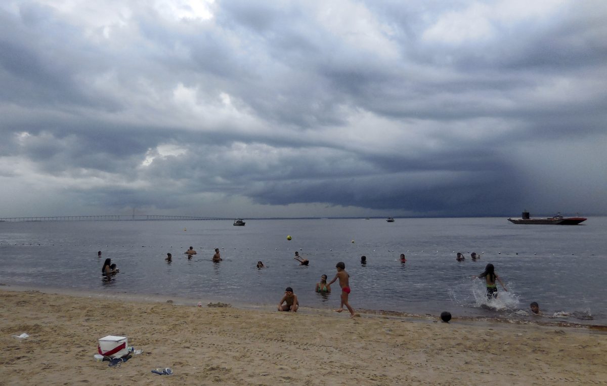 People swim in the Rio Negro in Manaus, Brasilia, Monday, June 16, 2014 despite  staying in the water despite downpours.       (AP Photo/Chris Lehourites)