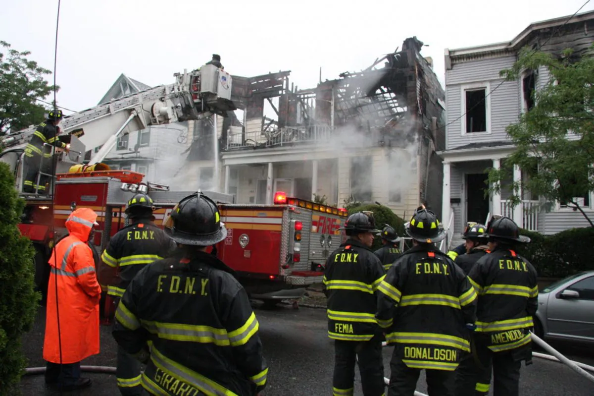 Firefighters continue working the scene of a fire that tore through three townhouses on New York City's Staten Island, on June 5, 2014.(AP Photo/Staten Island Advance, Irving Silverstein)