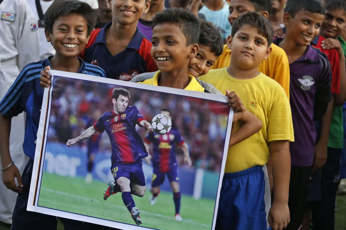 An Indian boy holds a poster of Argentina's Lionel Messi as sports enthusiasts gather at an event to celebrate the Soccer World Cup in Allahabad, India, Thursday, June 12, 2014. Nearly half the world's population, well over 3 billion spectators, is expected to watch soccer's premier event that kicks off in Brazil Thursday. (AP Photo/ Rajesh Kumar Singh)