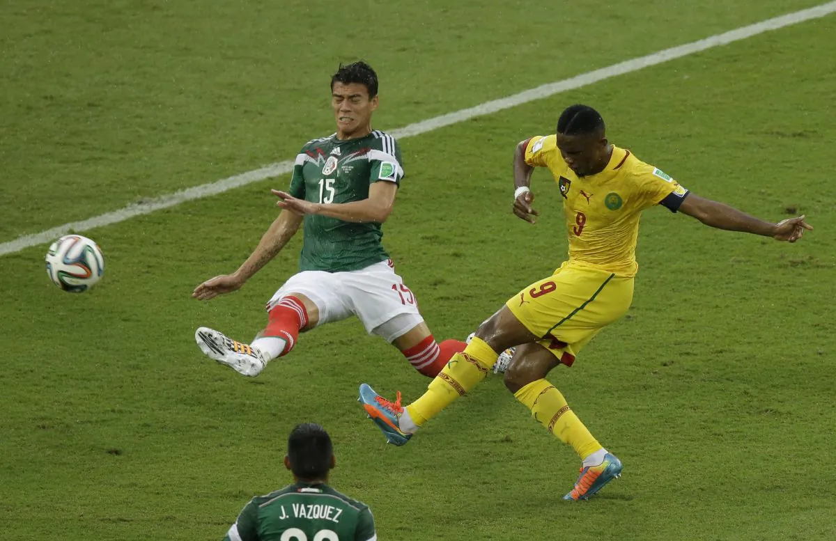 Cameroon's Samuel Etoo shoots as Mexico's Hector Moreno defends during the group A World Cup soccer match between Mexico and Cameroon in the Arena das Dunas in Natal, Brazil, Friday, June 13, 2014. (AP Photo/Hassan Ammar)