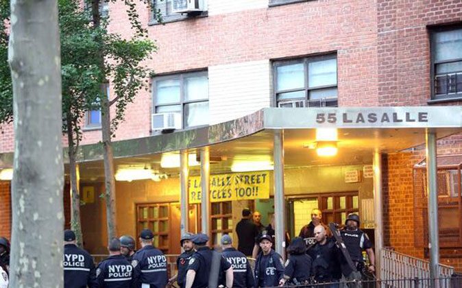Police officers stand outside a housing project during an early morning raid in West Harlem on Wednesday. (Courtesy of NYPD)