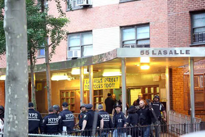 Police officers stand outside a housing project during an early morning raid in West Harlem on Wednesday. (Courtesy of NYPD)