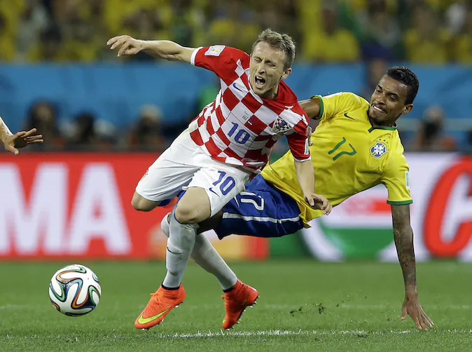 Croatia's Luka Modric is fouled by Brazil's Luiz Gustavo, right, during the group A World Cup soccer match between Brazil and Croatia, the opening game of the tournament, in the Itaquerao Stadium in Sao Paulo, Brazil, Thursday, June 12, 2014. (AP Photo/Kirsty Wigglesworth)
