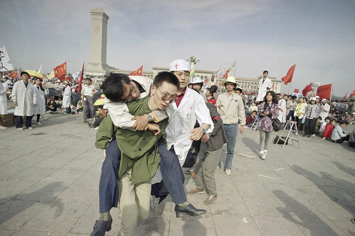 Medics rush a Beijing University student from Tiananmen Square after he collapsed on the third day of a hunger strike on May 16, 1989. A quarter century after the Communist Party’s attack on demonstrations centered on Tiananmen Square on June 4, 1989, the ruling party prohibits public discussion and 1989 is banned from textbooks and Chinese websites. (AP Photo/Sadayuki Mikami)