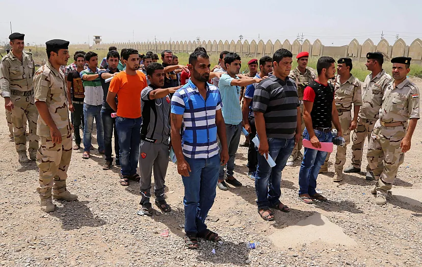 Iraqi men lining up outside of the main army recruiting center to volunteer for military service in Baghdad, Iraq, June 12.(AP Photo/ Karim Kadim, File) 