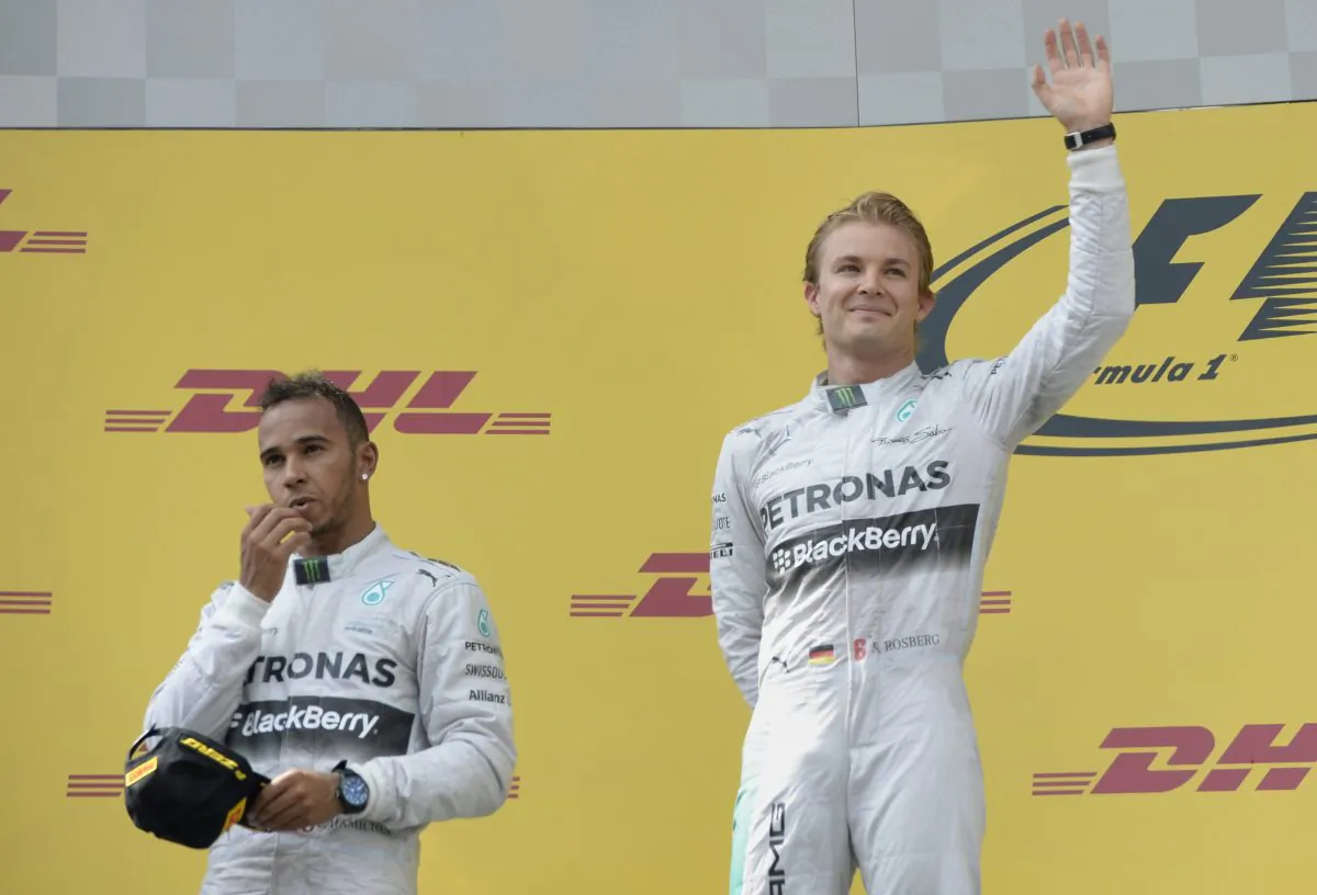 (L-R) Second placed Mercedes' British driver Lewis Hamilton, and teammate winner Mercedes' German driver Nico Rosberg wave on the podium after the Austrian Formula One Grand Prix at the Red Bull Ring in Spielberg on June 22, 2014. (Christof Stache/AFP/Getty Images)