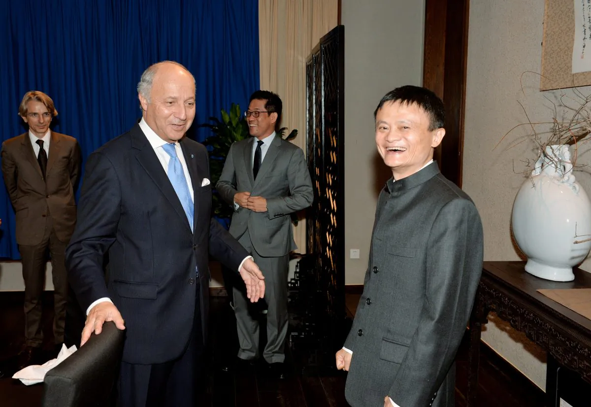 French Foreign Minister Laurent Fabius (L) meets with Jack Ma (R), chairman and founder of the Chinese e-commerce company Alibaba on May 16. A U.S. government report warns potential investors of the risks of investing in U.S.-listed Chinese companies, like Alibaba. (MARK RALSTON/AFP/Getty)