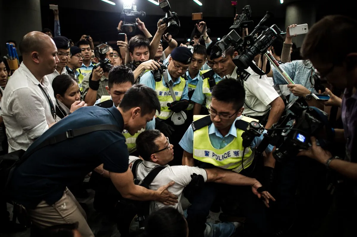 Riot police remove protesters from the grounds of the Legislative Council in Hong Kong, June 14, 2014. The protesters object to the government's plan to turn farmlands into housing estates. (Philippe Lopez/AFP/Getty Images)