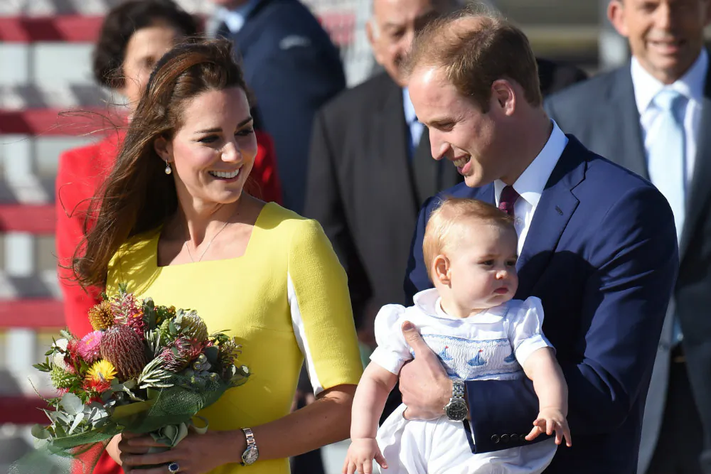 Britain’s Prince George (C) is held by his father Prince William (R) as his mother Catherine, the Duchess of Cambridge (L), looks on at Sydney airport on April 16, 2014. (William West/AFP/Getty Images)