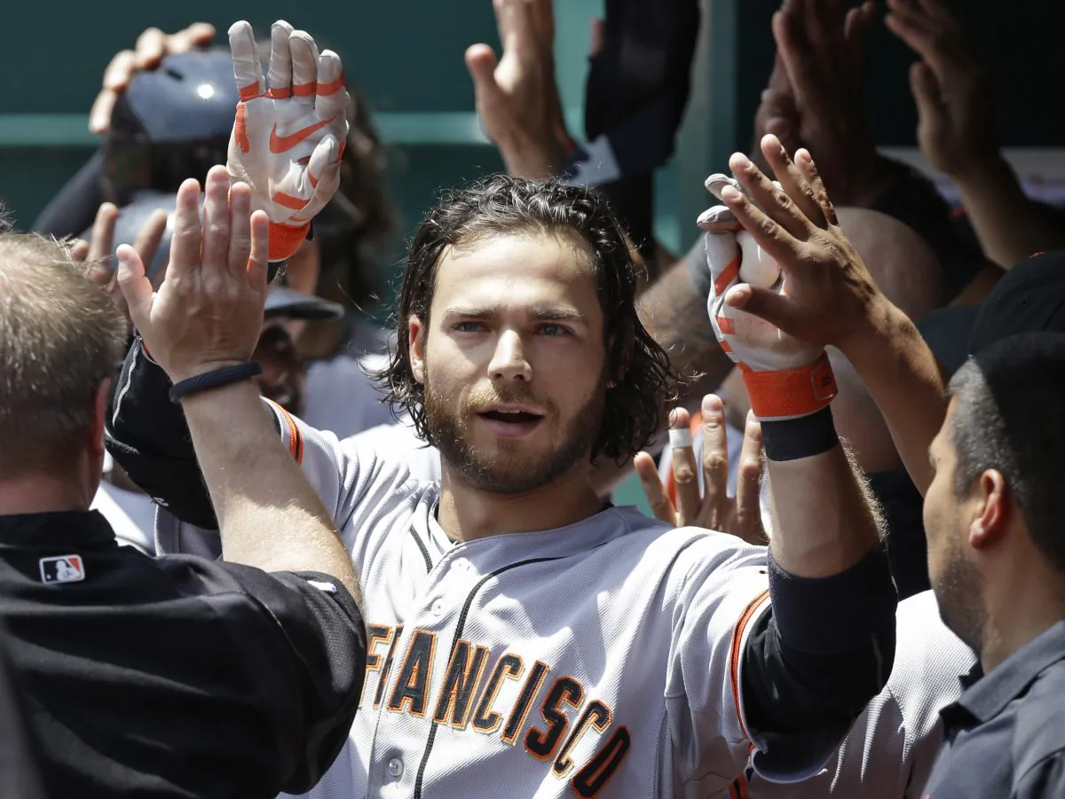 San Francisco Giants' Brandon Crawford is congratulated in the dugout after hitting a three-run home run off Cincinnati Reds starting pitcher Mike Leake in the fourth inning of a baseball game, Thursday, June 5, 2014, in Cincinnati. (AP Photo/Al Behrman)