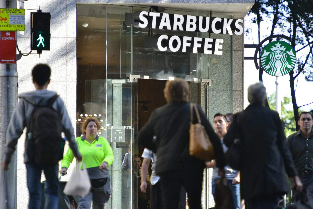 Pedestrians cross a street in front of a Starbucks coffee house in Sydney Australia on May 28, 2014. (Peter Parks/AFP/Getty Images)
