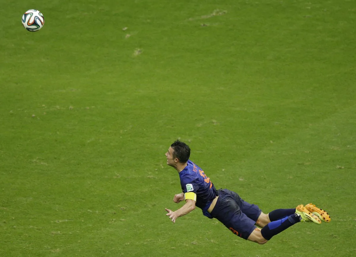 In this Friday, June 13, 2014 photo, Netherlands' Robin van Persie heads the ball to score during the group B World Cup soccer match between Spain and the Netherlands at the Arena Ponte Nova in Salvador, Brazil. The Dutchman's header that looped over a stranded Iker Casillas in the Spain goal was not only very special but historic. By taking his tally to 45 goals for his country, the Manchester United forward also became the first Dutch player to score in three consecutive World Cups.(AP Photo/Christophe Ena)