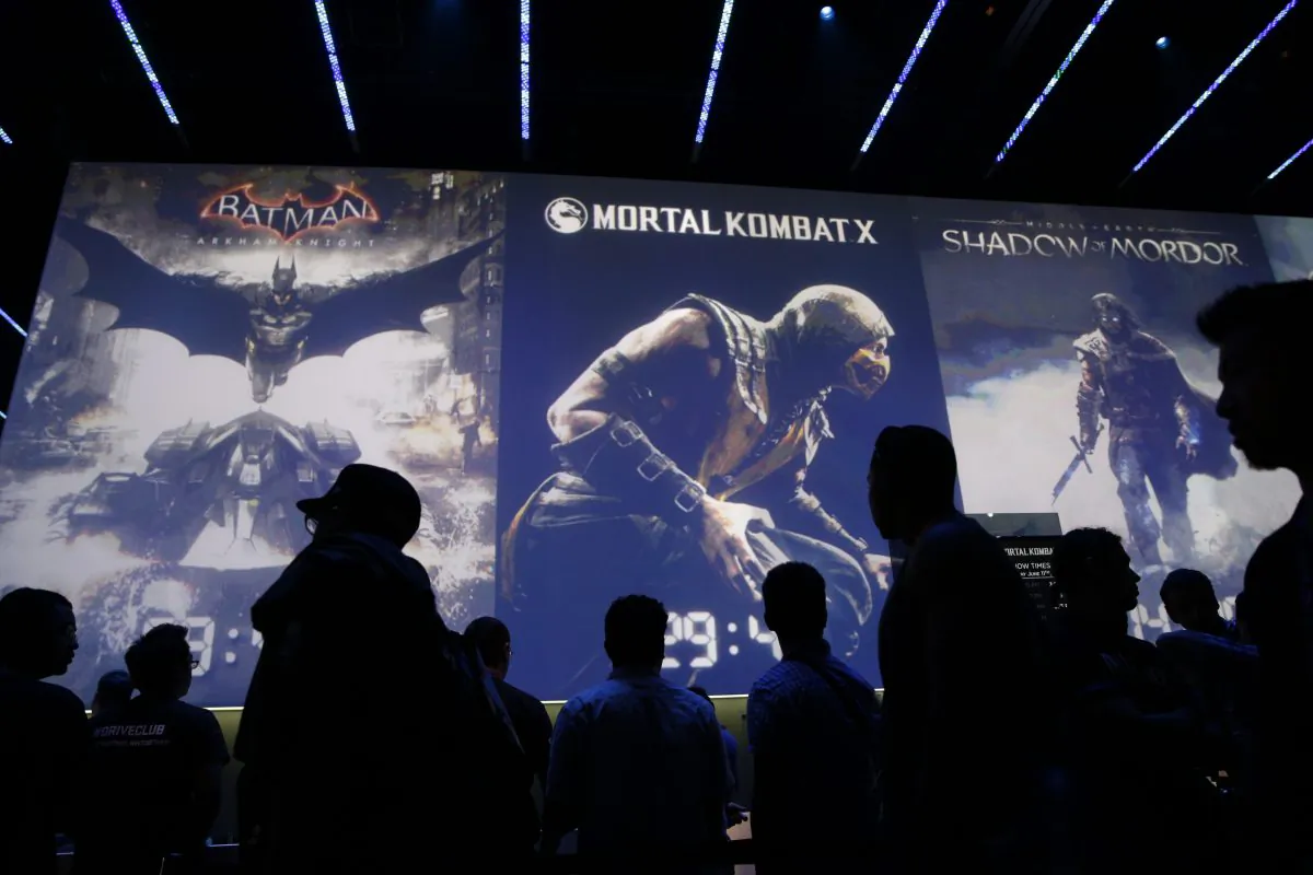 FILE - In this Wednesday, June 11, 2014 file photo, people wait in line for theater presentations for video games including Batman, Mortal Kombat X and Shadow of Mordor at the WB Games booth at the Electronic Entertainment Expo, in Los Angeles. At last week's E3, video game developers hyped upcoming titles featuring assassins, super-soldiers, vigilantes and demon hunters. The lack of female protagonists at the expo highlighted an ongoing issue that continues to haunt the video game industry.  (AP Photo/Jae C. Hong, file)