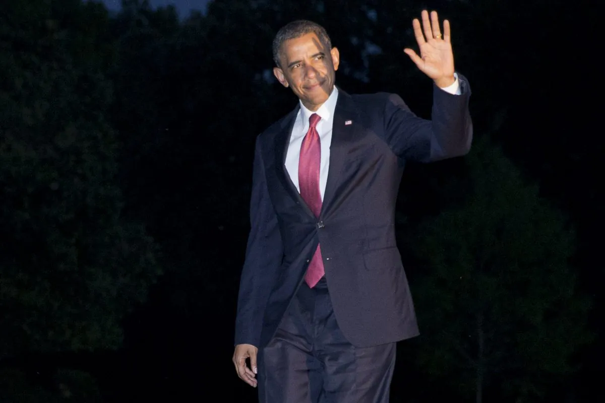 President Barack Obama waves to the media as he returns at dusk on the South Lawn of the White House in Washington, Friday, June 6, 2014, after attending remembrance activities on the 70th anniversary of D-Day in Normandy, France. (AP Photo/Jacquelyn Martin)