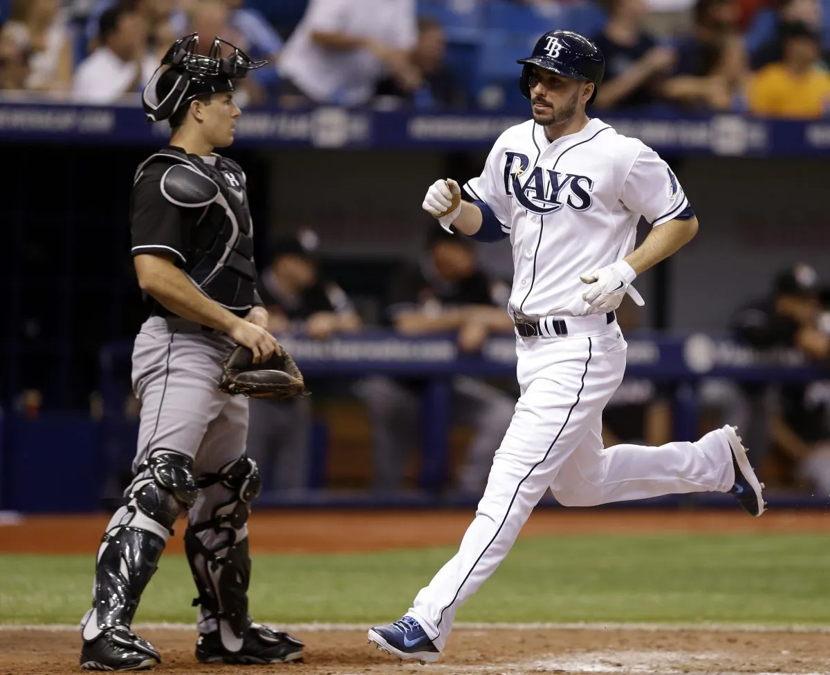 Tampa Bay Rays' Matt Joyce (R) scores in front of Miami Marlins catcher Jacob Realmuto on an RBI single by Jerry Sands during the sixth inning of an interleague baseball game in St. Petersburg, Fla., on June 5, 2014. (Chris O'Meara/AP Photo)