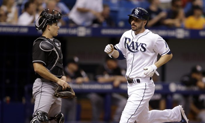 Tampa Bay Rays' Matt Joyce (R) scores in front of Miami Marlins catcher Jacob Realmuto on an RBI single by Jerry Sands during the sixth inning of an interleague baseball game in St. Petersburg, Fla., on June 5, 2014. (Chris O'Meara/AP Photo)