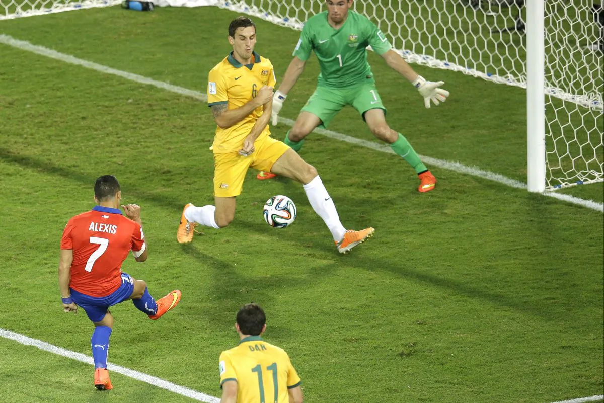 Chile's Alexis Sanchez, left, scores his team's first goal during the group B World Cup soccer match between Chile and Australia in the Arena Pantanal in Cuiaba, Brazil, Friday, June 13, 2014. (AP Photo/Michael Sohn)