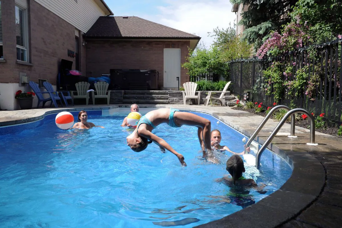A family has fun in their backyard pool in Burlington, Ont. Drowning remains a leading cause of death for teens and children in Canada, and the BC Coroners Service says more effective water safety education is needed, especially for males aged between 15 and 18. (The Canadian Press/Galit Rodan)