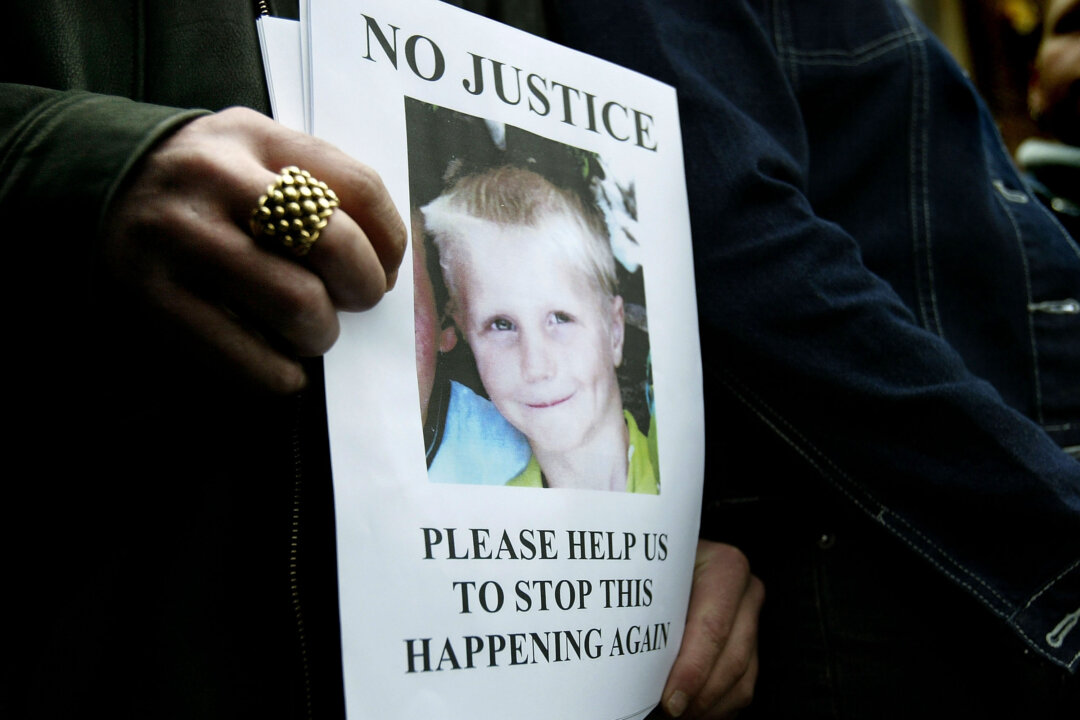 Relatives of nine-year-old Callum Oakford, killed by a hit-and-run driver, hold a poster bearing his image at Chichester Crown Court on February 12th, 2004. New Public Health reports are calling for local authorities to improve child accident protection strategies. (Ian Waldie/Getty Images)