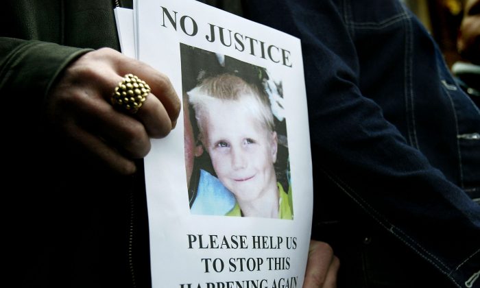 Relatives of nine-year-old Callum Oakford, killed by a hit-and-run driver, hold a poster bearing his image at Chichester Crown Court on February 12th, 2004. New Public Health reports are calling for local authorities to improve child accident protection strategies. (Ian Waldie/Getty Images)
