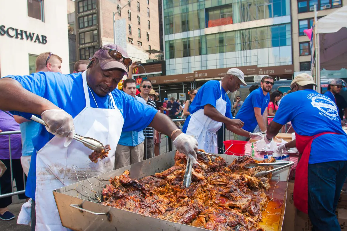 The hog is pulled apart and doused with sauce. (Rob Counts/Epoch Times)