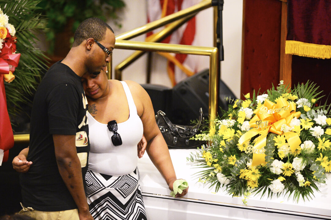 Emerald Garner (R) stands next to the coffin of her father, Eric Garner, during his funeral at Bethel Baptist Church in the Brooklyn borough of New York on July 23. (AP Photo/New York Daily News, James Keivom)