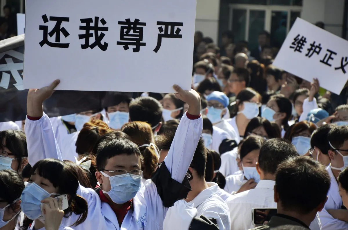 Hospital workers hold banners as they protest against attacks on medical workers outside the No. 1 People's Hospital in Wenling, east China's Zhejiang province, on Oct. 28, 2013. The relationship between patients and hospitals has often been characterized by mistrust, and sometimes outright violence. (Jin Yunguo/AFP/Getty Images)