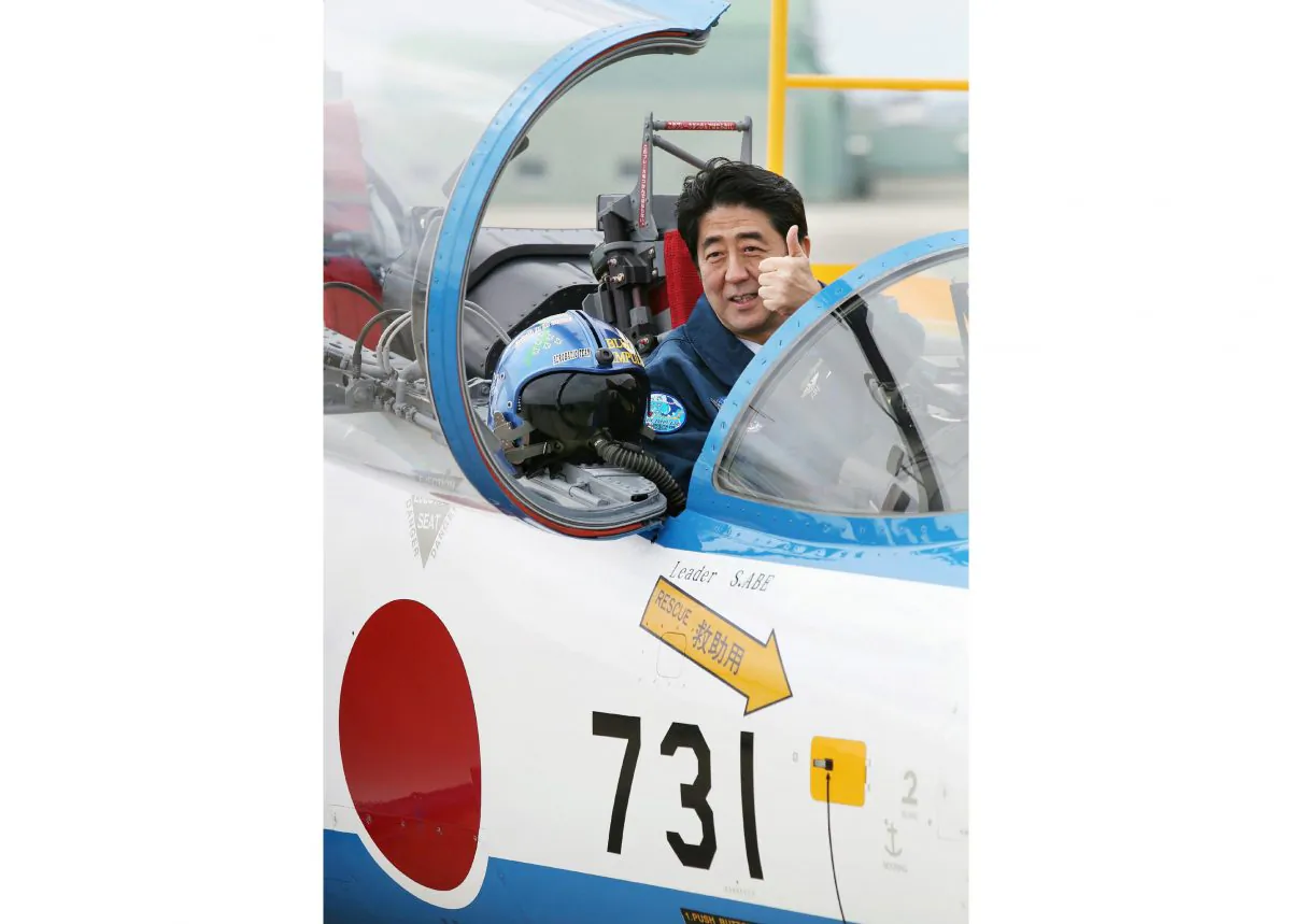 Japanese Prime Minister Shinzo Abe poses inside a T-4 training jet plane of the Air Self-Defense Force's Blue Impulse flight team at the ASDF base in Higashimatsushima, Miyagi Prefecture, on May 12, 2013. Abe has recently announced a policy committing Japan to defending its allies, an expansion of the permitted use of Japan's military forces. (Jiji Press/AFP/Getty Images)