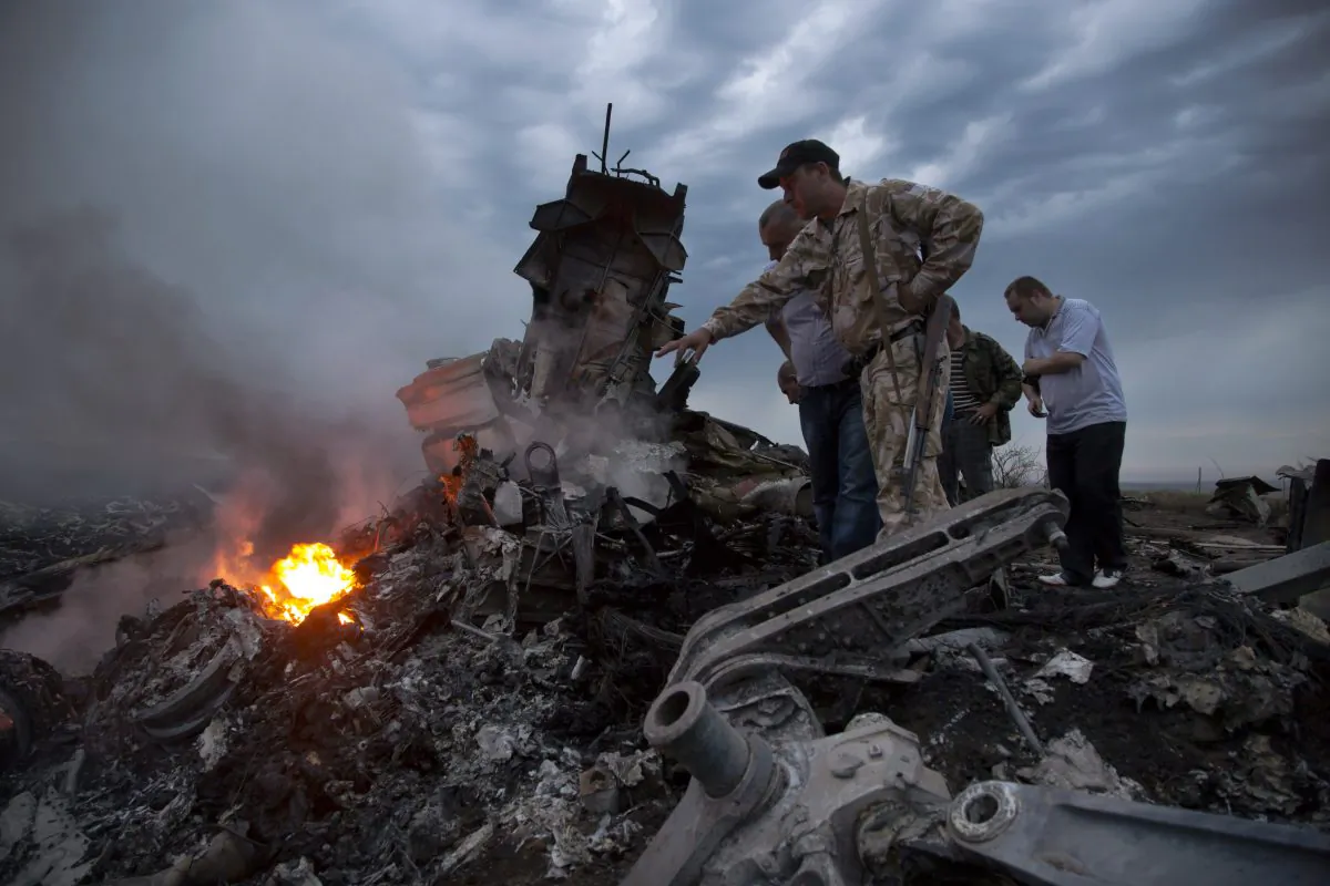 People inspect the crash site of a passenger plane near the village of Grabovo, Ukraine, Thursday, July 17, 2014. (AP Photo/Dmitry Lovetsky)
