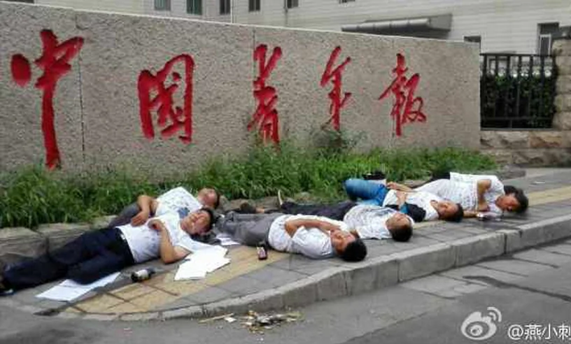 Seven petitioners lay on the ground, seemingly unconscious, several appearing to foam at the mouth, after drinking pesticide in a group suicide attempt outside the offices of the China Youth Daily in Beijing on July 16. They staged the attempted suicide in protest of their houses being demolished with little compensation. (Weibo.com) 