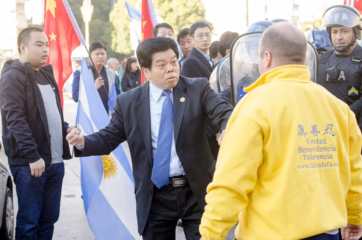 The president of the CASRECH (Chamber of Supermarkets and Self-Service Restaurants Owned by Chinese Residents in Argentina) threatens a Falun Gong practitioner in Buenos Aires, Argentina, on July 19, 2014. (Epoch Times)