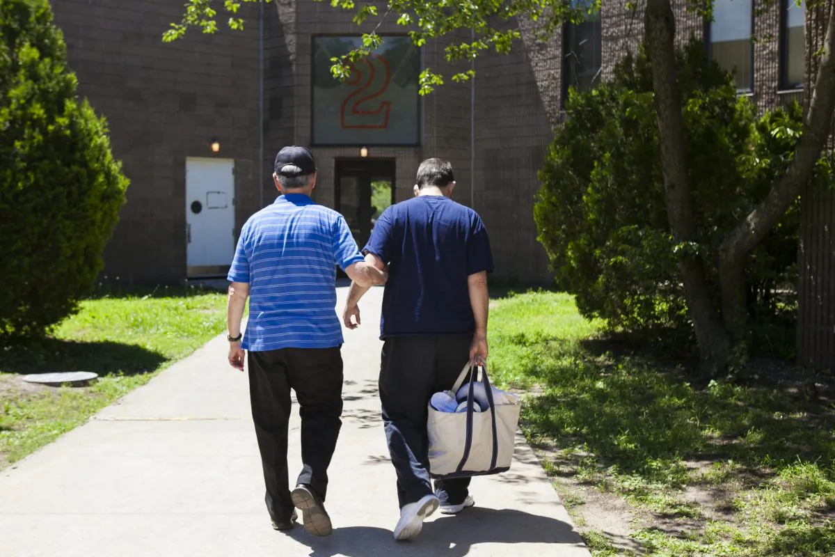 Anthony Cosentino and his son, John Cosentino, at the Brooklyn Developmental Center, June 20, 2014. The center is one of the two developmental centers in NYC that are slated to close under Governor Cuomo's initiative to transition adults with developmental disorders from institutions to group homes. Some fear group homes cannot adequately care for those who have severe disorders. (Samira Bouaou/Epoch Times)