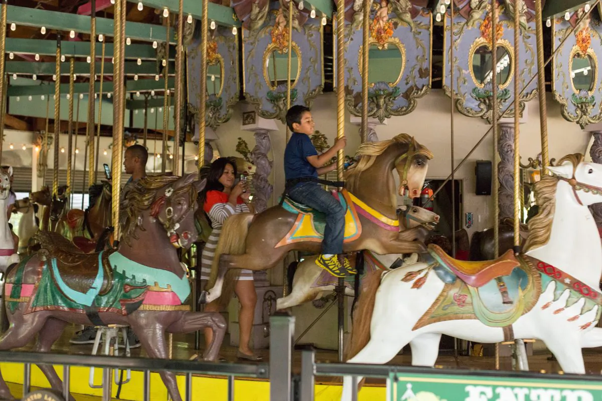 A boy rides the Forest Park Carousel June 30, 2014. The landmarked carousel was carved in 1903 by the Daniel Muller, who is recognized as one of the greatest designers of carousels. It is one of two that still remain across the country. (Laura Cooksey/Epoch Times)