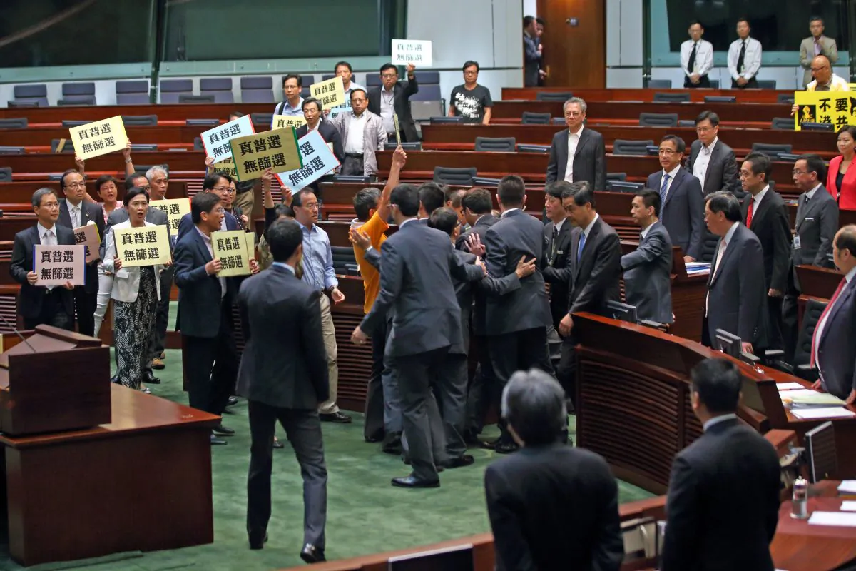 Over 20 pan-democratic LegCo members collectively walk out to protest against Chief Executive Leung Chun-ying during Question and Answer Session in LegCo chamber on July 3, 2014. They are holding banners demanding for “Genuine Universal Suffrage, No Screening.” (C.S. Poon/Epoch Times)