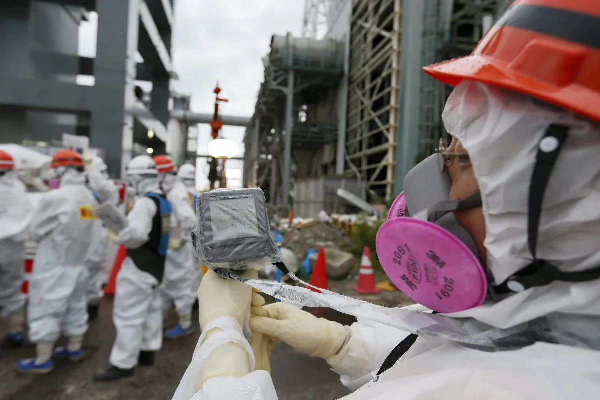 A Tokyo Electric Power Co.'s staff measures the radiation level as workers work on the construction of an ice wall at the tsunami-crippled Tokyo Electric Power Co.'s Fukushima Daiichi Nuclear Power Plant in Okuma, Fukushima Prefecture, northeast of Tokyo on July 9, 2014. Tokyo Electric Power Co. (TEPCO) will build a frozen ice wall around the buildings of Units 1 to 4 at the tsunami-devastated nuclear power plant to stop radiation-contaminated water from flowing to the sea. TEPCO has been struggling with massive amounts of toxic water as the operator continues to pump water into three reactors to keep them cool. The plant suffered meltdowns at three of its six reactors after a tsunami swept through the facilities in March 2011. (Kimimasa Mayama/AFP/Getty Images)